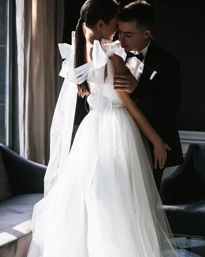 Minimal A-line silhuette wedding dress. Tulle wedding dress with bows. Modern bridal gown online.